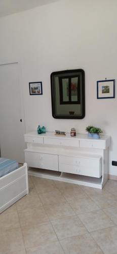 a white entertainment center with a tv on a wall at Casa Rosellina Piano Primo in Cefalù