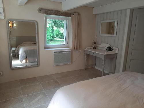 une chambre avec un lit, un lavabo et un miroir dans l'établissement Adorable Chaumière traditionnelle plage à pied, à Fouesnant