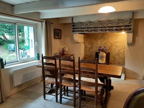 une salle à manger avec une table et des chaises et une fenêtre dans l'établissement Adorable Chaumière traditionnelle plage à pied, à Fouesnant