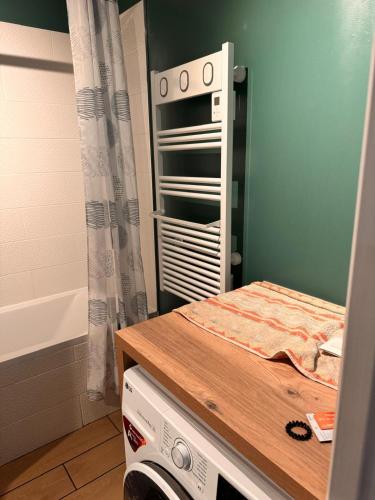 La petite salle de bains est pourvue d'une table et d'une baignoire. dans l'établissement Appartement Avec Terrasse proche Disney, à Montévrain