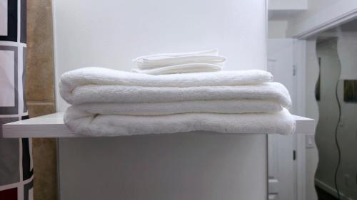 a pile of towels sitting on a counter in a bathroom at Cozy & Spacious 1-Bedroom SW Calgary near SpruceMeadows in Calgary