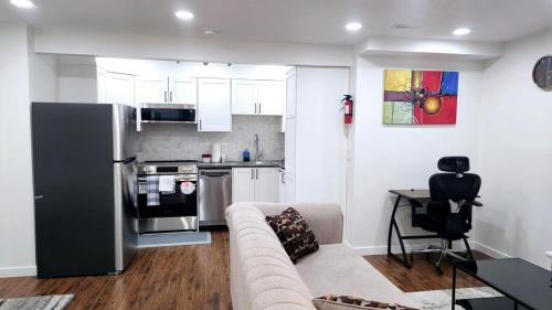 a living room with a couch and a kitchen at Cozy & Spacious 1-Bedroom SW Calgary near SpruceMeadows in Calgary