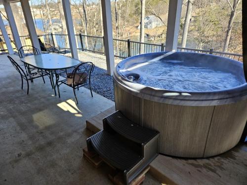 a jacuzzi tub on a porch with a table at Beechwood Cove in Moneta