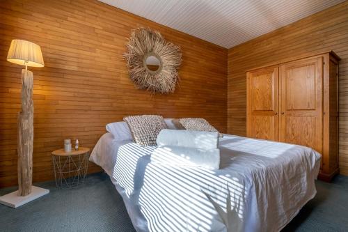 une chambre avec un lit et un mur en bois dans l'établissement Maison avec jardin, à Sainte-Marie de Ré