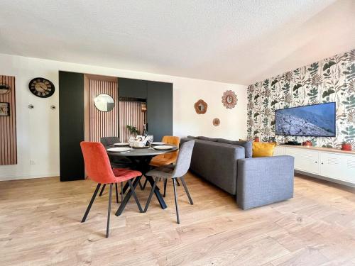 ein Wohnzimmer mit Tisch und Couch in der Unterkunft Baux'M Chic - Alpilles, Grand Studio Cosy, Clim, 4 personnes in Les Baux-de-Provence