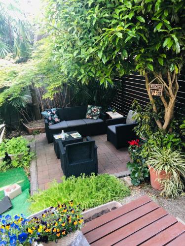 a patio with couches and flowers in a garden at Airportside Chillhouse in Toyonaka