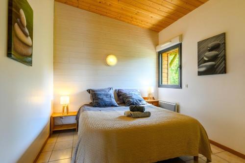 une chambre avec un lit avec un ours en peluche dessus dans l'établissement Lodge milieu - Piscine privée Terrasse -, à Roquetaillade