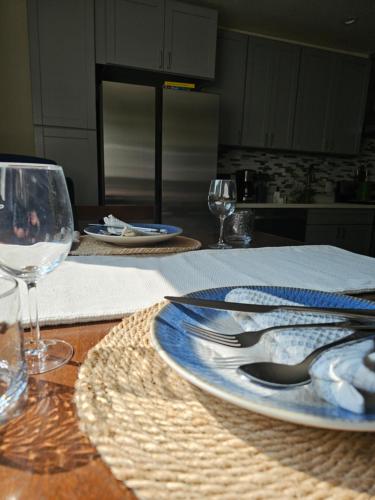 a table with a blue and white plate and wine glasses at Cozy Home Away From Home in Granada Hills