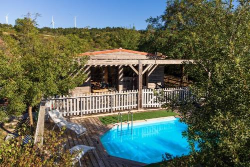 une maison avec une piscine et une clôture blanche dans l'établissement Lodge milieu - Piscine privée Terrasse -, à Roquetaillade