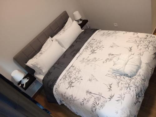 a bedroom with a bed with white sheets and pillows at H La Cabaña in Pozuelo de Alarcón