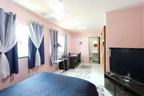 a bedroom with a bed and a flat screen tv at Casa perto Expo Center Norte e Anhembi 1km in Sao Paulo