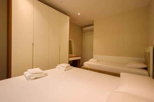 a room with two beds and a cabinet and a bathroom at SanPietro Vacation Apartments in Durrës