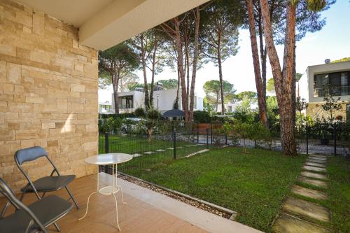 a patio with a table and chairs and a yard at SanPietro Vacation Apartments in Durrës