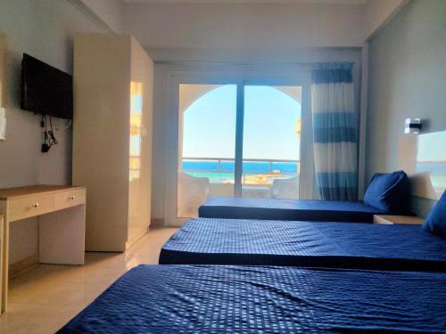 a hotel room with two beds and a view of the ocean at Aquarium Seaview accomodations in Hurghada