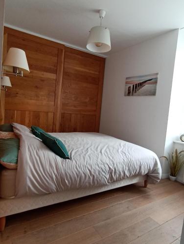 une chambre avec un lit avec une tête de lit en bois dans l'établissement Appartement Saint-Malo vue mer, à Saint-Malo