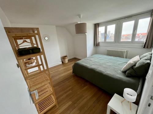 une chambre avec un lit et une échelle en bois dans l'établissement Le bon’heurt, à Le Portel