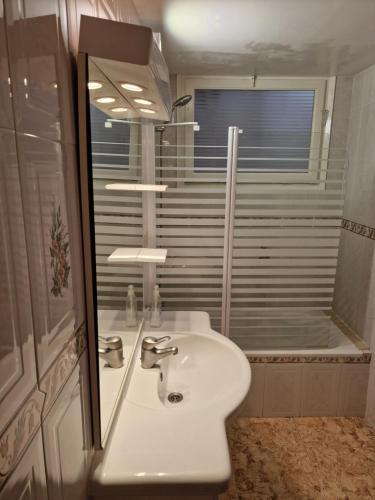 a bathroom with a sink and a mirror and a shower at SunandSea in L'Estartit