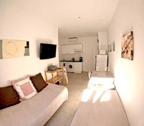 un salon avec un canapé et une cuisine dans l'établissement Résidence Angela à 7 minutes à pieds du Palais, plage..., à Cannes