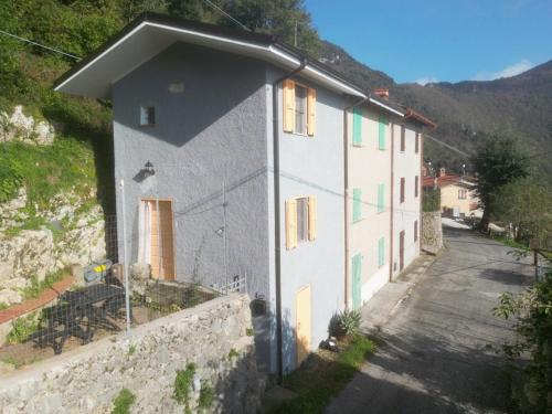 a white building with a wall next to a street at CASA SANT`ANNA DI STAZZEMA in Culla