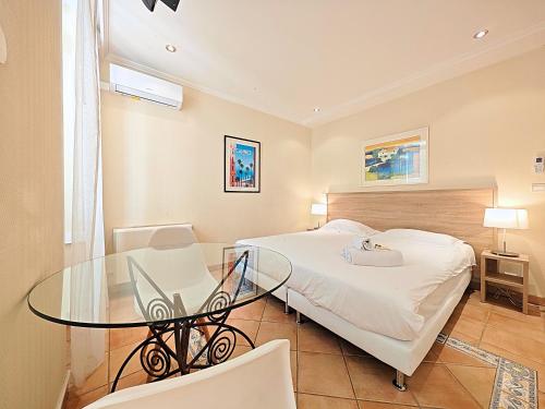 a bedroom with a glass table and a bed at Viva Riviera Residence Commandant André in Cannes
