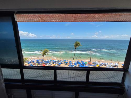 a view of a beach with umbrellas and the ocean at Farol Barra Flat in Salvador