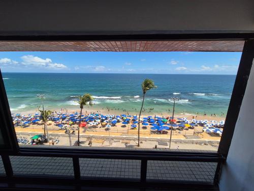 a view of a beach with umbrellas and the ocean at Farol Barra Flat in Salvador