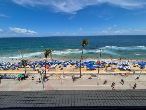 a view of a beach with umbrellas and the ocean at Farol Barra Flat in Salvador