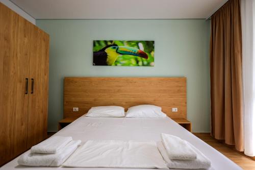 a bedroom with a large bed with a wooden headboard at SanPietro Vacation Apartments in Durrës