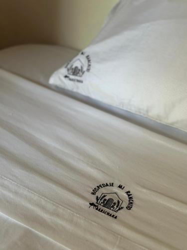 a close up of a white pillow on a bed at Mi Ranchito, Centro in Barichara