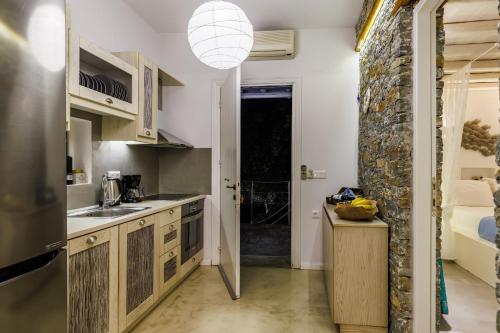 a kitchen with a large stone wall and a sink at Evlalia Studios & Villas in Skopelos Town