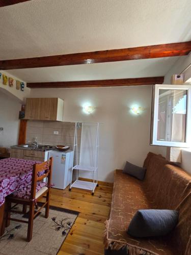 a living room with a couch and a kitchen at Domaćinstvo Krstajić - Rural holiday in Žabljak