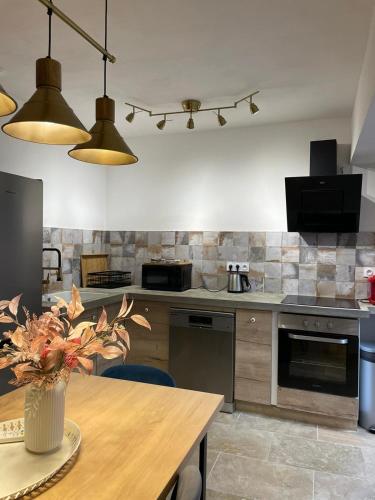 a kitchen with a table and some lights in it at Riverside flat between Isle sur la Sorgue & Gordes in Fontaine-de-Vaucluse