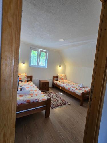a bedroom with two beds and a window at Domaćinstvo Krstajić - Rural holiday in Žabljak