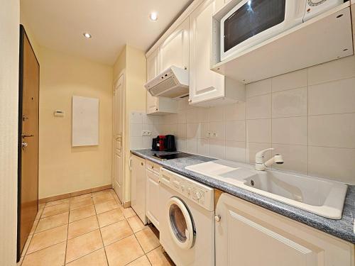 a kitchen with a sink and a washing machine at Viva Riviera Residence Commandant André in Cannes