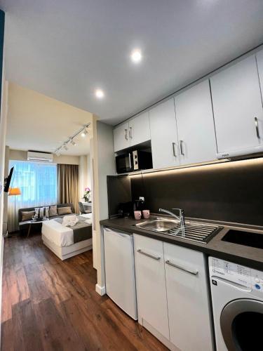 a kitchen with a sink and a living room at 70 steps studio A, 50 meters from Dimokratias metro station in Thessaloniki