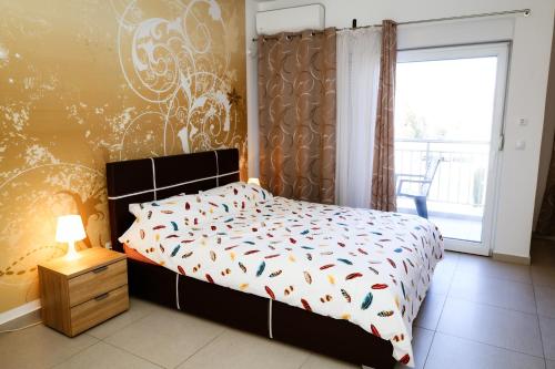 a bedroom with a bed with an orange and white comforter at Apartman Zorana in Tivat