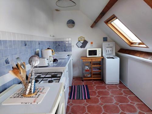 une cuisine avec une cuisinière et un réfrigérateur dans l'établissement Les Pins, plage à pied, à Fouesnant