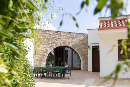 a patio with a green table and chairs at Il giardino di Ve' in Lecce