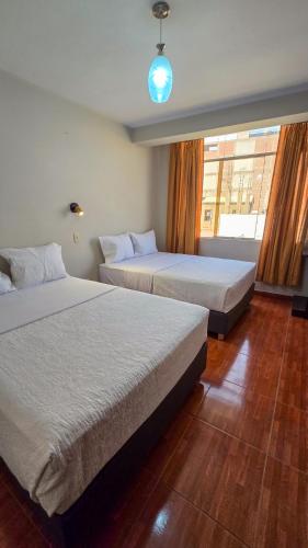 a bedroom with two beds and a window at Huara Hs in Tacna