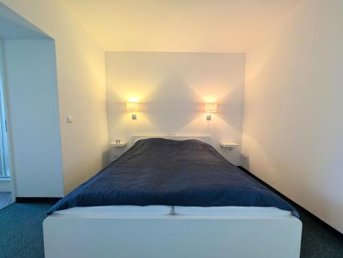 a bedroom with a bed with two lights on the wall at Gästehaus Am Hothertor in Görlitz