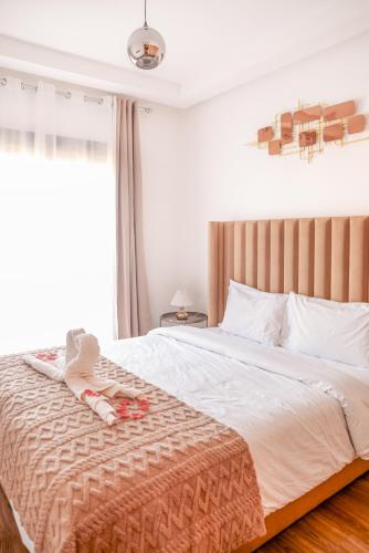a bedroom with a bed with a blanket and a window at Eva cosy - Clim, Wifi, Jardin à 10min de l'Aéroport in Marrakech