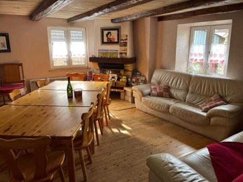 a living room with a table and a couch at Gite du Val du Pâtre in Orschwihr