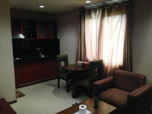 a living room with a table and a chair at Hidden Pearl Hotel (Janus Luxury Suites) in Angeles