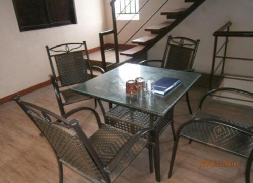 a table and chairs in a room with stairs at Hidden Pearl Hotel (Janus Luxury Suites) in Angeles