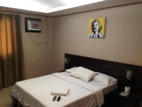 a small bedroom with a bed with a white bedspread at Hidden Pearl Hotel (Janus Luxury Suites) in Angeles