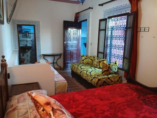 a living room with a couch and a bed at Riad Idrissi in Meknès
