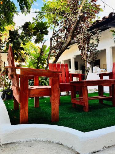 two wooden benches sitting on the grass in a yard at Urban Nest Hostel in Santa Ana