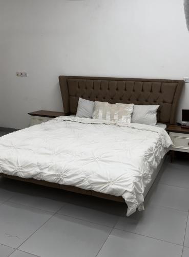 a large bed with white sheets and pillows at Asayl resort in Baghdad