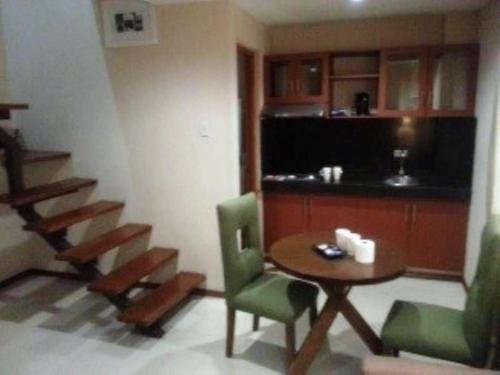 a room with a table and chairs and a staircase at Hidden Pearl Hotel (Janus Luxury Suites) in Angeles