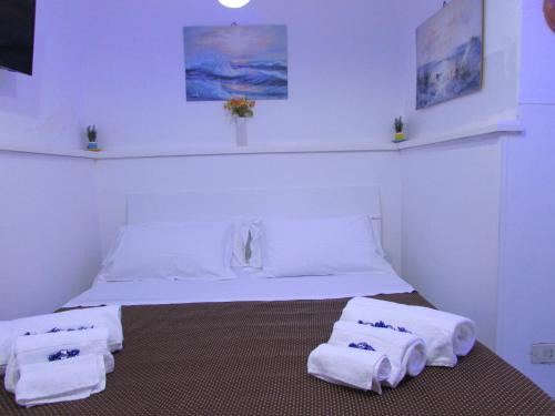 una camera bianca con un letto e asciugamani di la casetta in piazzetta capri a Capri